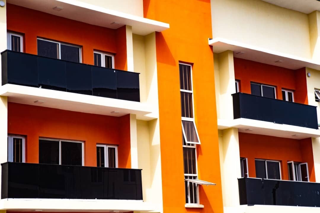 Close-up of orange and cream balconies with black glass balustrades